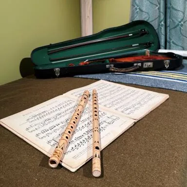 Bamboefluiten, bladmuziek en een vioolkist uit de tentoonstelling