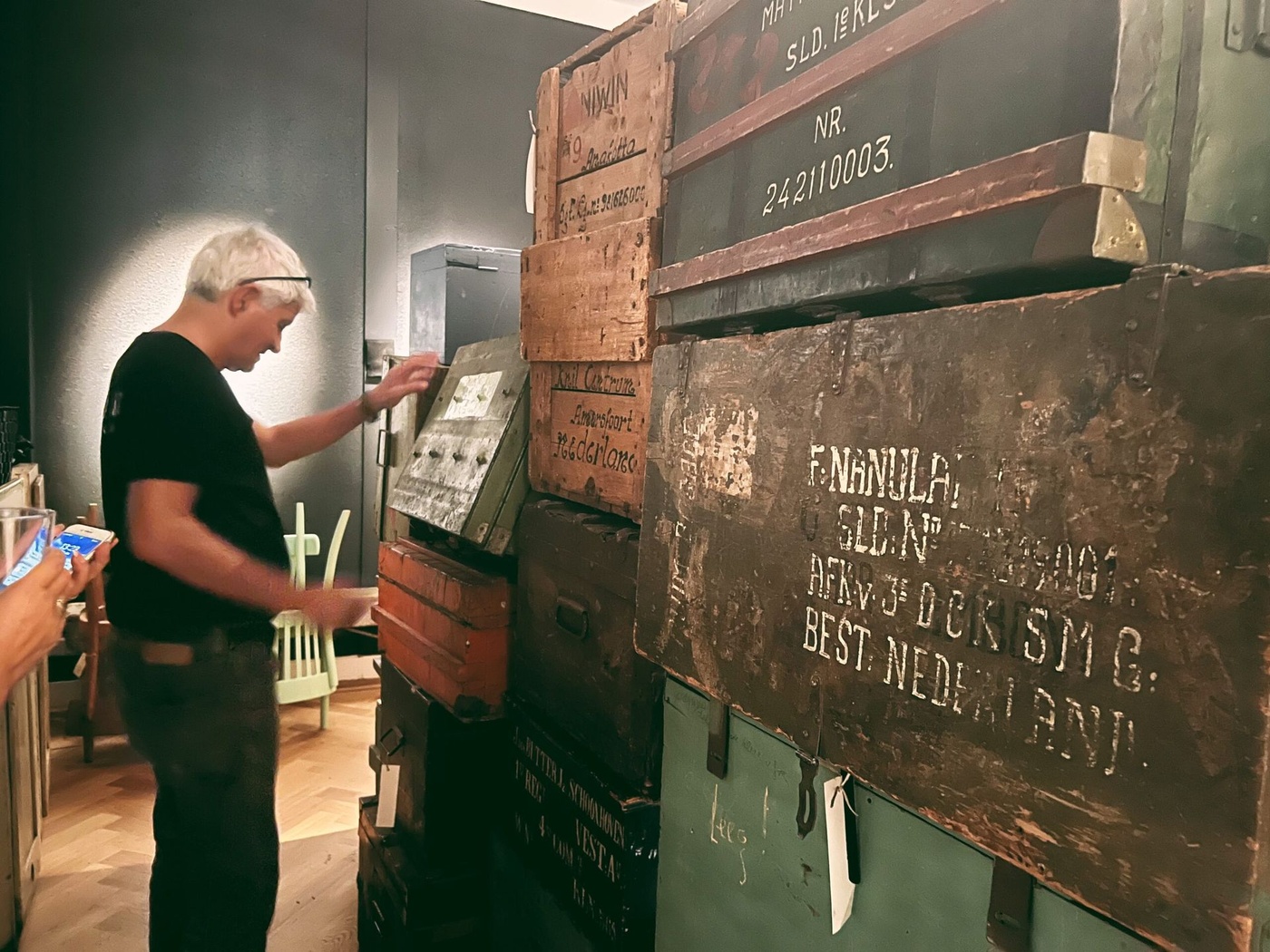 Een collega opent een van de historische kisten tijdens de opbouw van de tentoonstelling Uitgepakt